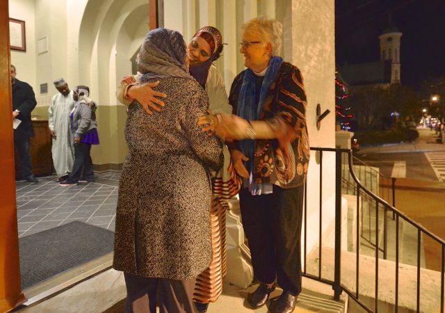  Sister Munira Salim Abdalla of the Islamic Umma of Fredericksburg and Gay M. Rahn, an Associate Rector at St. George's Episcopal Church in Fredericksburg, Va., greet a guest to a "Prayer Vigil for Unity.”