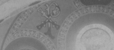 Detail above the chancel windows left. This is Chi Rho symbolism. You can see it in the #6 stained glass window on the nave level